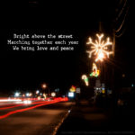 Bright above the street; Marching together each year; We bring love and peace.